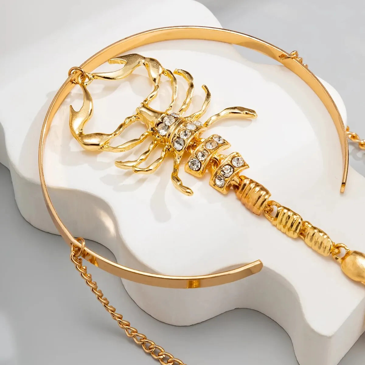 Gold scorpion arm cuff with chain details